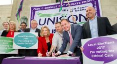 UNISON and Swansea Labour group leader sign the charter in front of a UNISON Cymru / Wales banner