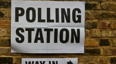 Polling station sign on a brick wall