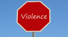 Red stop sign with the word violence on it