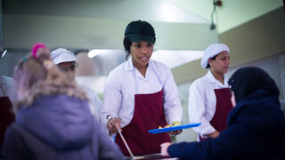 School meal worker serving children