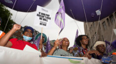 Four UNISON members carrying a banner march through the streets of London