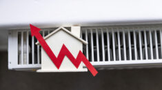 Rising red arrow on a model of a building on top of a radiator, showing rising heating costs