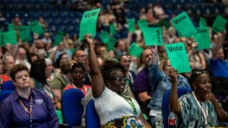 Conference delegates hold up vote cards