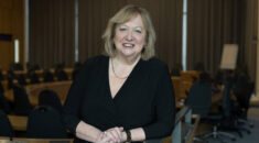 Christina McAnea leans on a railing with her hands clasped, wearing a black top