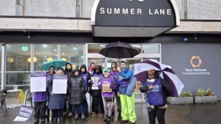 UNISON members holding signs on their picket line reading 'no pay, no way' and 'fair pay now'