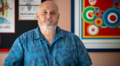 Andy Hewston stands in a blue shirt