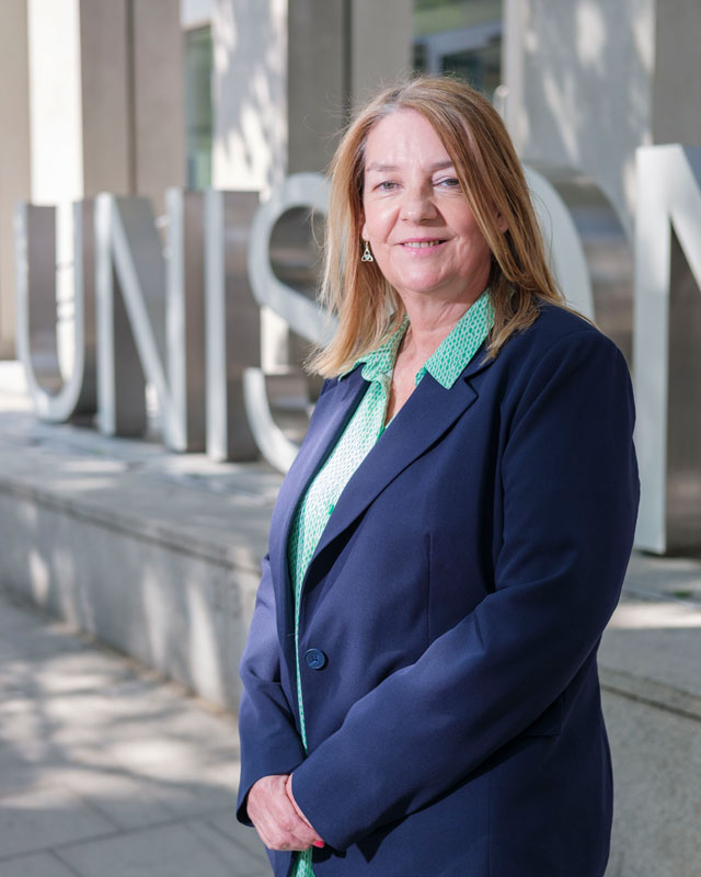 Maggi Ferncombe, standing in front of the UNISON sign at UNISON Centre