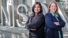 Shantha David and Maggi Ferncombe standing back to back with UNISON sign in the background
