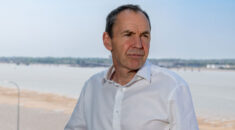 Portrait of Mike Berners-Lee, with a beach and water behind him.