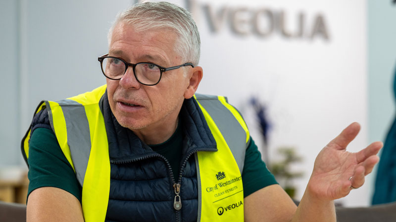 Photo of Glen Litton, speaking to someone out of shot. 'Veolia' is on the wall behind him 