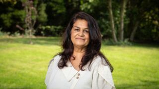 Portrait of Bindu Parmar, in a part with trees behind her