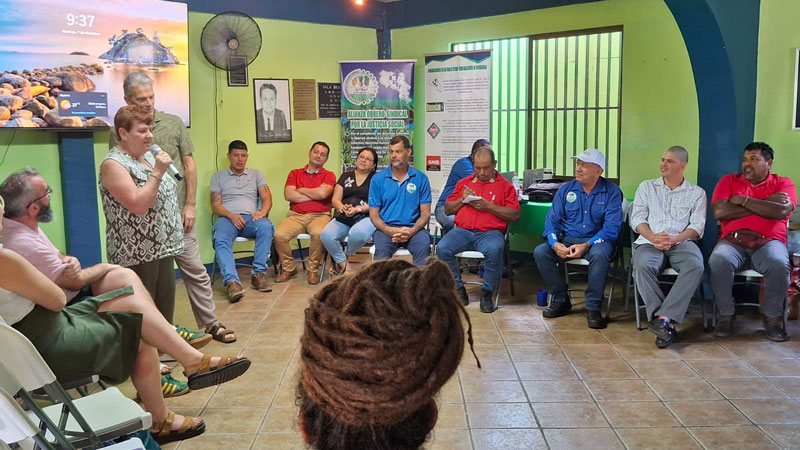 Margaret McKee standing and speaking to a gathering of seated workers